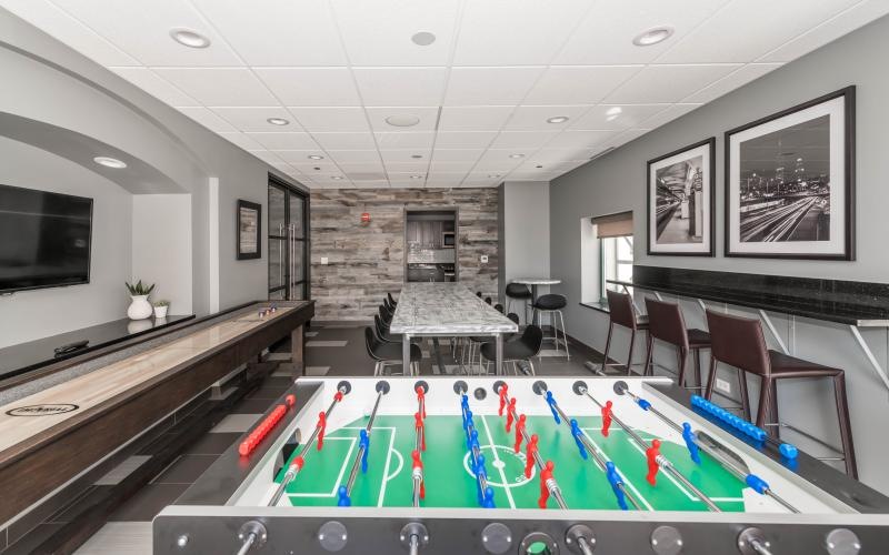 a room with a foosball table and chairs